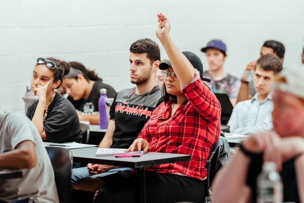 A College of Liberal Arts student raises her hand to ask a question in class.